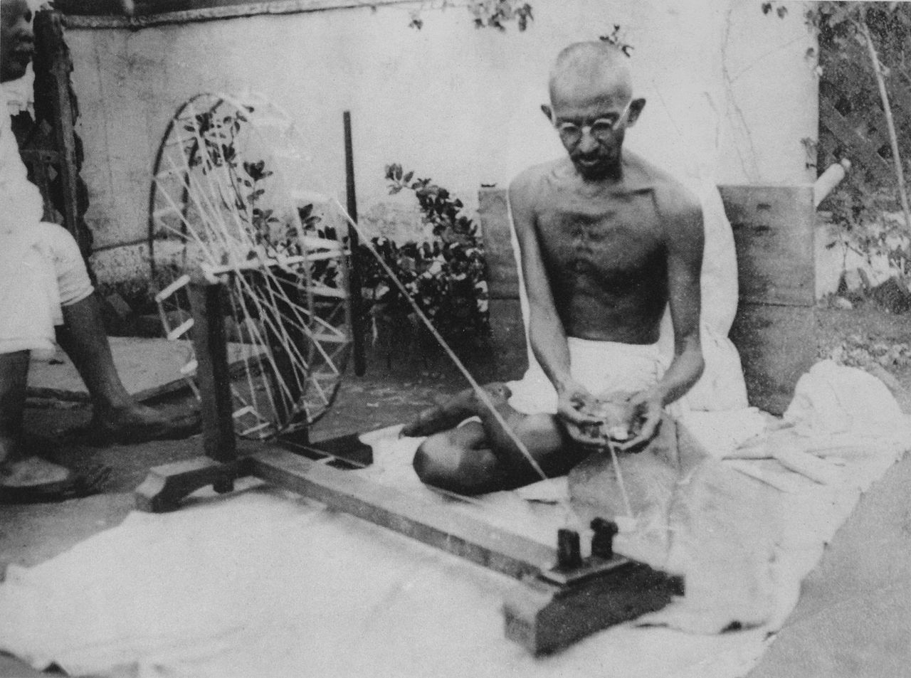 Mahatma Gandhi in his 70s, spinning yarn on a charkha.